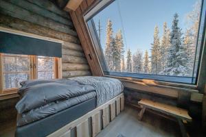 een slaapkamer in een blokhut met een bed en een raam bij Lapland Lodge in Tepsa