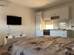 a bedroom with a large bed and a kitchen at Apartman Gavric in Doboj