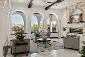 a living room with arched windows and a fireplace at Greek Goddess, Private Heated Pool and Hot Tub in Hurricane