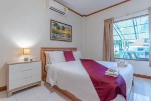 une chambre avec un grand lit et une fenêtre dans l'établissement Resort 5-3BR Huge Pool, BBQ, 300m-Beach, 8 mins to Walking Street, à Pattaya (sud) 17 autres photos