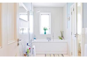 a white bathroom with a tub and a window at Modern Homestay 15 minutes to Dublin Airport in Ballyboughal