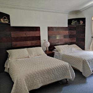- 2 lits dans une chambre avec des têtes de lit en bois dans l'établissement Refugio de los Angeles, à Huasca de Ocampo
