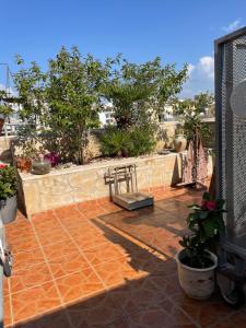 a patio with a bench and plants and a fence at MP Cozy Apartment Near the Sea in Paphos City
