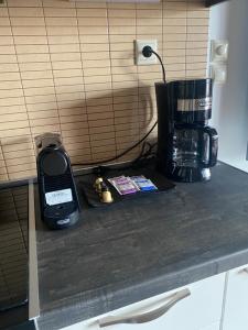 un teléfono móvil sentado en un mostrador junto a una cafetera en The Grey Apartments, en Volos