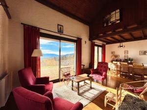 a living room with a table and chairs and a large window at La bergerie d'Egat: Chalet authentique avec vue in Égat