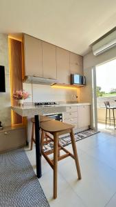 uma cozinha com uma mesa e um banco num quarto em Apartamento em prédio residencial em FOZ DO IGUAÇU em Foz do Iguaçu