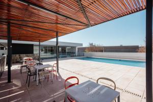 a patio with tables and chairs and a swimming pool at Rent a Flat - Río Cuarto in Río Cuarto