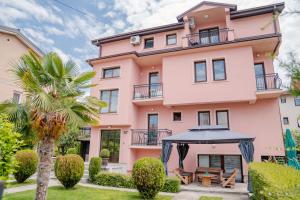 a pink building with an umbrella in front of it at Apartments Serafimoski in Ohrid