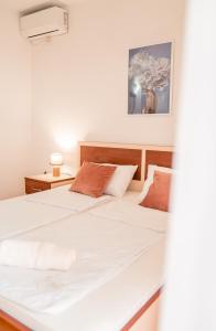 2 Betten in einem kleinen Zimmer mit einem weißen Bett in der Unterkunft Apartments Serafimoski in Ohrid