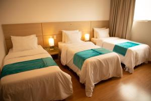 una habitación de hotel con 3 camas en una habitación en Hotel Franco en Dionísio Cerqueira