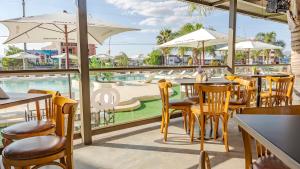 un restaurante con mesas y sillas y una piscina en Wooden Hotel en Villa Carlos Paz