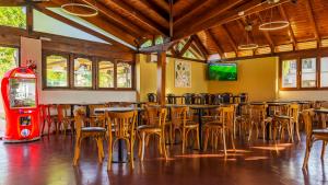 un restaurant avec des tables, des chaises et une machine rouge dans l'établissement Wooden Hotel, à Villa Carlos Paz