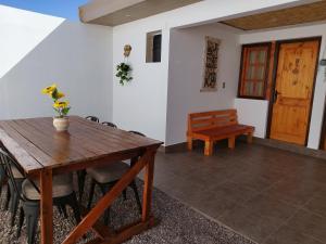 comedor con mesa de madera y banco en Hostal Belen en San Pedro de Atacama