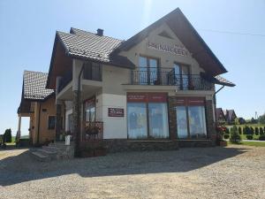 a building with a sign on the front of it at Mrowca Noclegi Pokoje Gościnne in Gronków