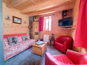 a living room with a red couch and a tv at Chalet Saint-Martin-de-Belleville, 4 pièces, 6 personnes - FR-1-344-642 in Saint-Martin-de-Belleville