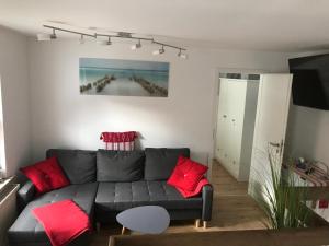 a living room with a gray couch and red pillows at Meeresrauschen in Graal-Müritz
