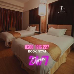 2 camas en una habitación de hotel con reloj rosa en Diamond Lodge, en Karachi