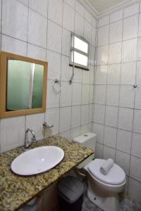 y baño con lavabo, aseo y espejo. en Hotel da Canoa, en Arraial do Cabo