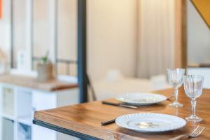 een houten tafel met twee borden en glazen erop bij Elegant flat near the centre of Bordeaux - Welkeys in Bordeaux