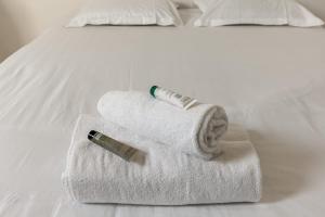 een stapel handdoeken op een bed met een thermometer bij Design house in the center of Deauville - Welkeys in Deauville