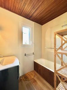 a bathroom with a tub and a sink and a window at La bergerie d'Egat: Chalet authentique avec vue in Égat