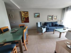 ein Wohnzimmer mit einem blauen Sofa und einem Tisch in der Unterkunft Apartamento en Sueños de Denia III muy cerca de la playa y del pueblo in Denia