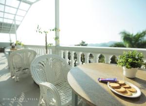 a table on a balcony with a plate of cookies at Himalayan Villa in Dehradun