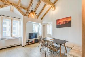 - une salle à manger avec une table, des chaises et une télévision dans l'établissement Appartement Jorasses - Welkeys, à Chamonix-Mont-Blanc