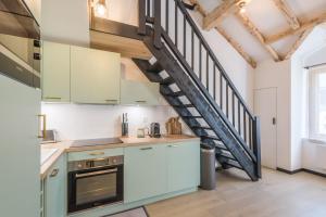 une cuisine avec un escalier en colimaçon dans un loft dans l'établissement Appartement Jorasses - Welkeys, à Chamonix-Mont-Blanc