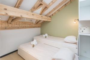 - 2 lits dans une chambre dotée de plafonds en bois dans l'établissement Appartement Jorasses - Welkeys, à Chamonix-Mont-Blanc
