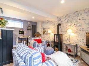 a living room with blue and white striped chairs at Tower End Cottage in Woodbridge