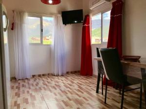 a dining room with red curtains and a table and chairs at LA MILAGROS ZORZAL COLORADO in Merlo