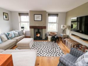uma sala de estar com um sofá e uma lareira em Cae Du em Llanfairpwllgwyngyll