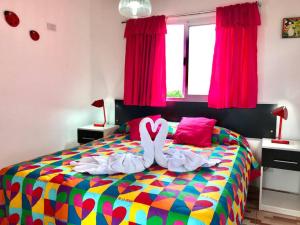 a bedroom with a colorful bed with a ribbon on it at LA MILAGROS ZORZAL COLORADO in Merlo +21 photos