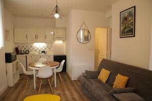 a living room with a couch and a table and a kitchen at Maison Candela in Argelès-Gazost