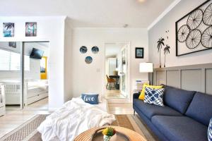 a living room with a blue couch and a bedroom at King Garden Suite - 10 mins to Beach and LAX in Gardena