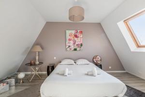 ein Schlafzimmer mit einem weißen Bett und einem Fenster in der Unterkunft Maison Avocette - Welkeys in La Rochelle