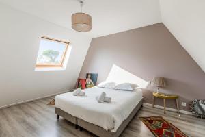 ein Schlafzimmer mit einem großen Bett und einem Fenster in der Unterkunft Maison Avocette - Welkeys in La Rochelle