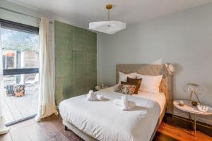 ein Schlafzimmer mit einem Bett und einem großen Fenster in der Unterkunft Maison Avocette - Welkeys in La Rochelle