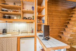 a kitchen with wooden cabinets and a sink and a tv at Charming apartment with view on the Mont Blanc - Welkeys in Megève