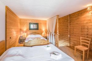 a bedroom with a bed and a chair in a room at Charming apartment with view on the Mont Blanc - Welkeys in Megève