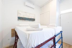 2 camas en una habitación con paredes blancas en Coqueto apartamento en la calle Caribe. A/C WIFI, en Madrid