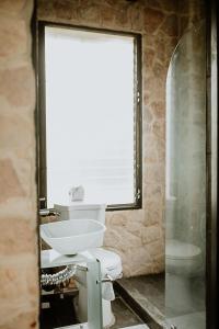y baño con aseo blanco y lavamanos. en Castillo Tambor Resort & Restaurant en Tambor