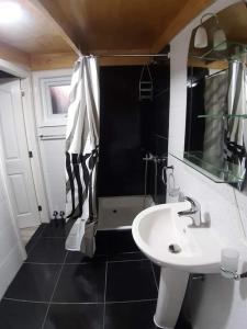 a black and white bathroom with a sink and a shower at Departamento con acceso independiente - English spoken in Punta Arenas