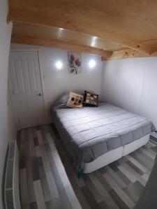 a small bedroom with a bed in a room at Departamento con acceso independiente - English spoken in Punta Arenas