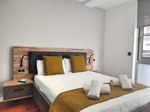 1 dormitorio con 1 cama blanca grande con almohadas amarillas en Victoria Cordoba Center, en Córdoba