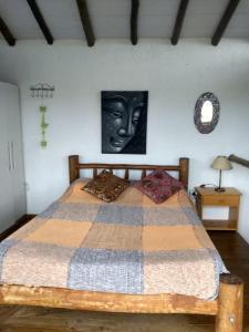 a bedroom with a large bed with a picture on the wall at Pousada Morgana, Praia do Rosa in Praia do Rosa