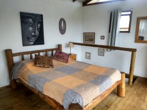 a bedroom with a bed with a black face on the wall at Pousada Morgana, Praia do Rosa in Praia do Rosa
