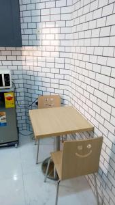a table and two chairs next to a brick wall at Résidence La Digue Cité Vauvert in Saint-Louis