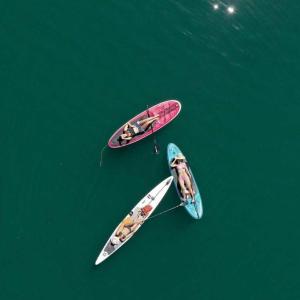 twee surfplanken in het water naast een boot bij Hospedaje CLUB CEAN a orilla del Lago Calima in Club Las Anonimos